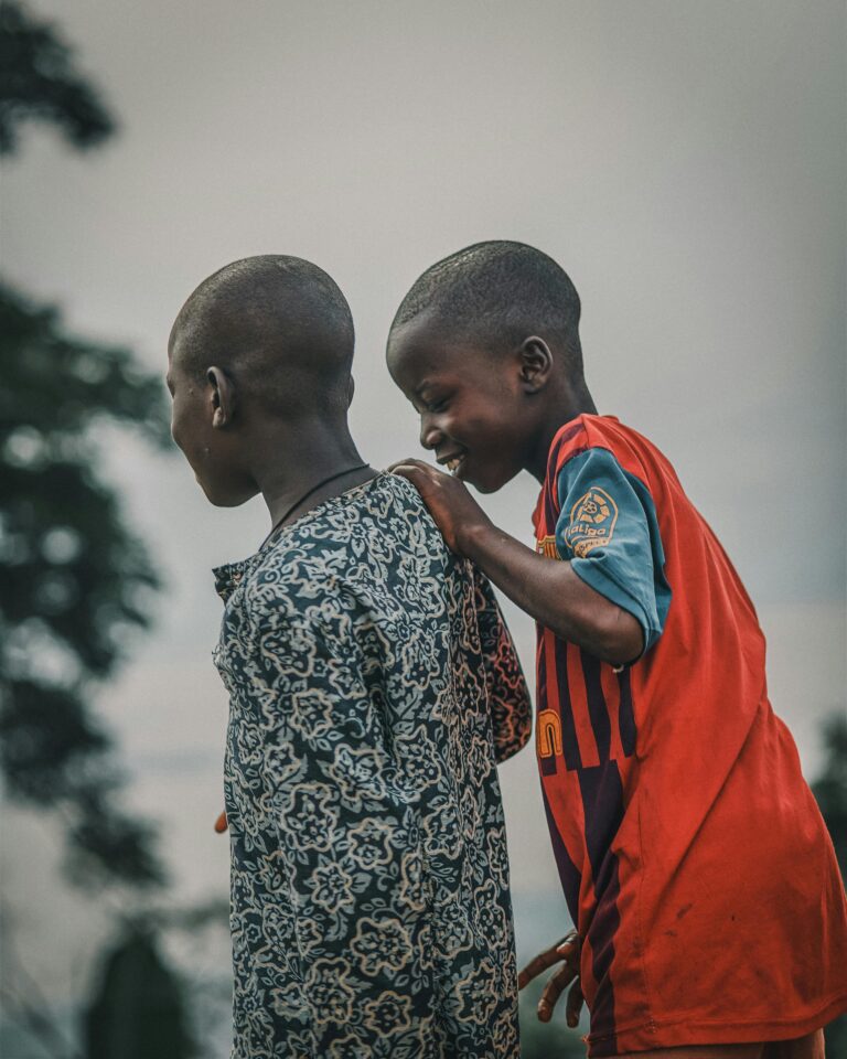 Two boys enjoy a playful moment outdoors, showcasing youthful friendship and joy.